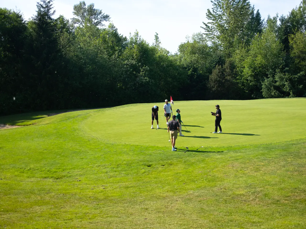A foursome finishing out a hole together on the green