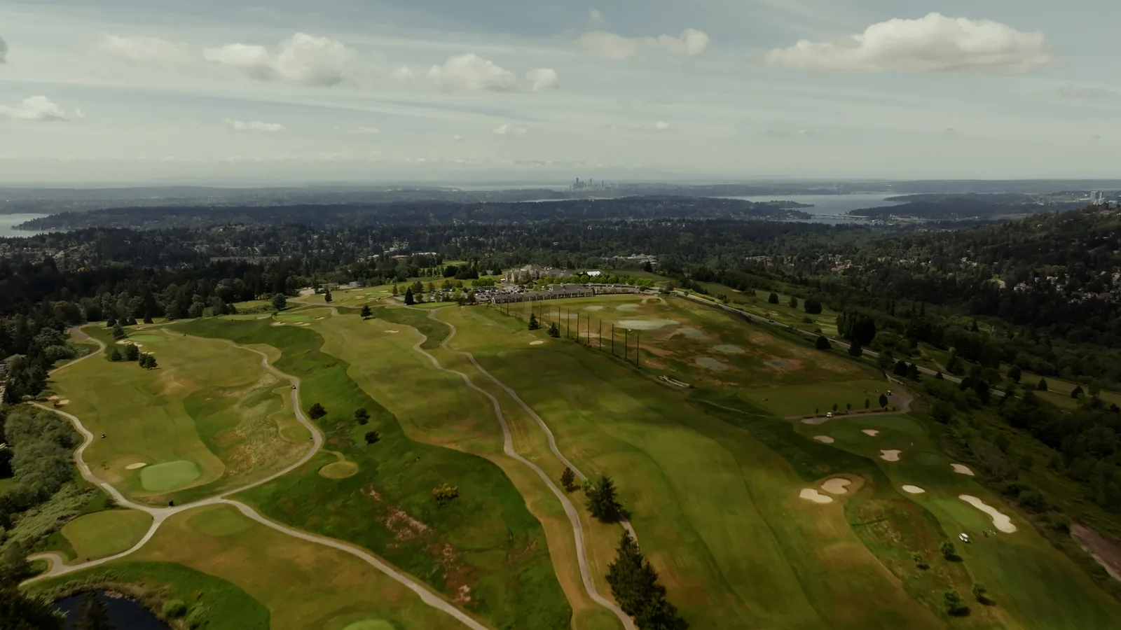 An aerial view of fairways, greens, and surrounding Pacific Northwest neighborhoods